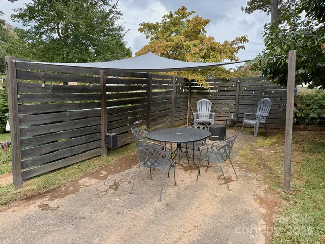 a backyard of a house with table and chairs