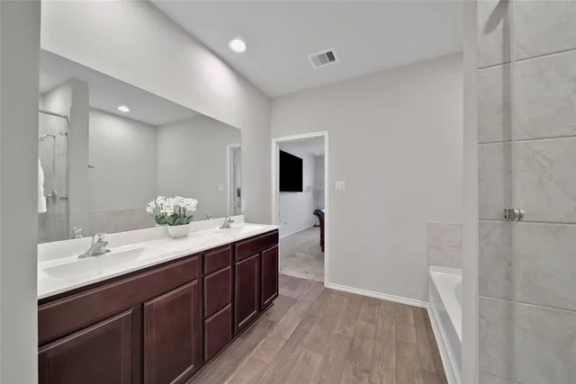 a spacious bathroom with a double vanity sink and a mirror