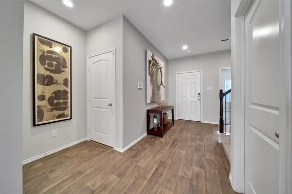 a view of a hallway with wooden floor and entryway