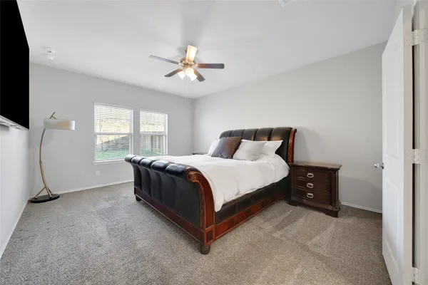 a spacious bedroom with a bed and a large window