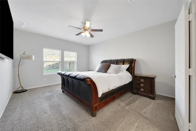 a spacious bedroom with a bed and a large window