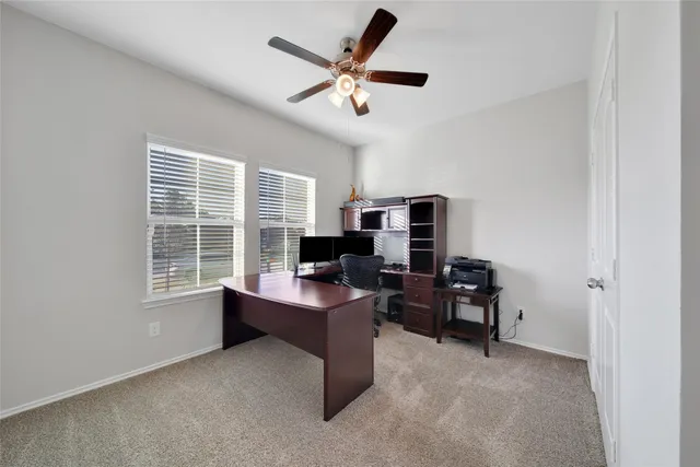 a view of a workspace with furniture and a window