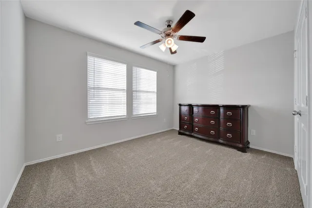 a living room with furniture and a ceiling fan