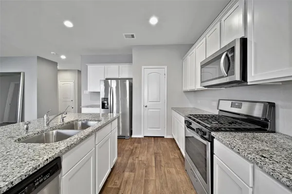 a kitchen with stainless steel appliances granite countertop a sink stove and refrigerator