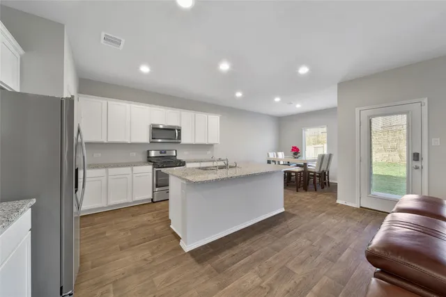 a kitchen with white cabinets and stainless steel appliances