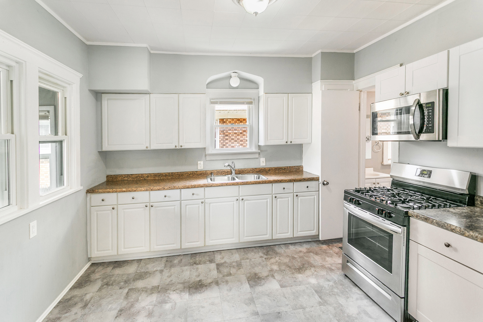705 Nicholson Street Joliet, IL 60435 - Photo 6 of 26 a kitchen with granite countertop a sink stove top oven and cabinets