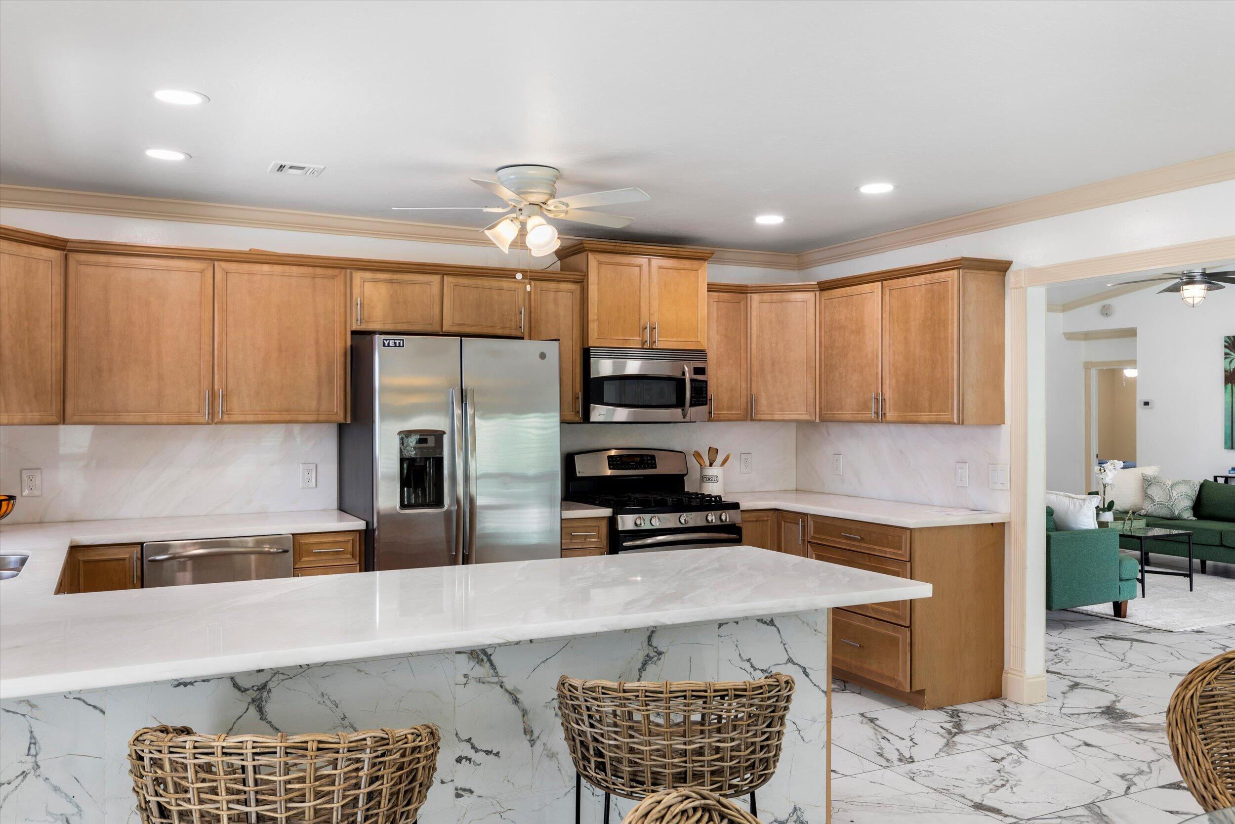 21025 3rd Avenue Cudjoe, FL 33042 - Photo 9 of 43 a kitchen with stainless steel appliances a refrigerator a stove a sink and a center island