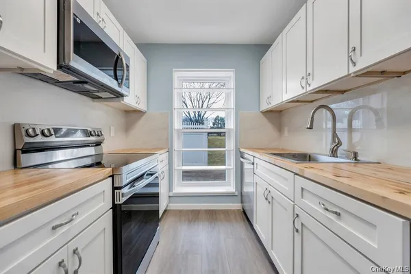 a kitchen with granite countertop a stove microwave and sink