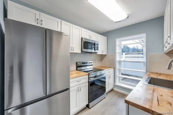 a kitchen with granite countertop a refrigerator stove and sink