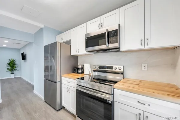 a kitchen with stainless steel appliances a stove microwave and sink