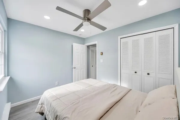 a bedroom with a large bed chandelier and a window