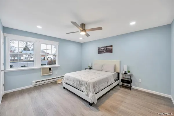 a bedroom with a large bed chandelier and a window