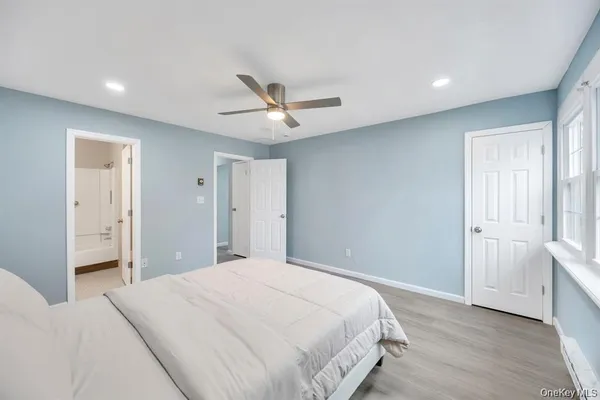 a spacious bedroom with a bed and a ceiling fan