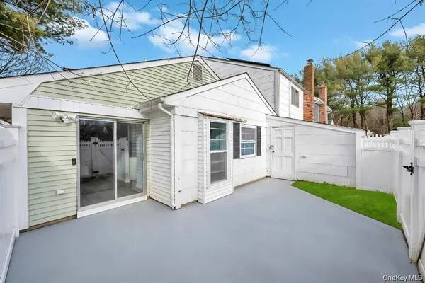 a view of a white house with a large tree