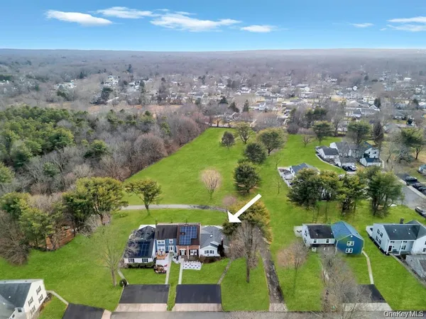 an aerial view of residential houses with outdoor space and trees
