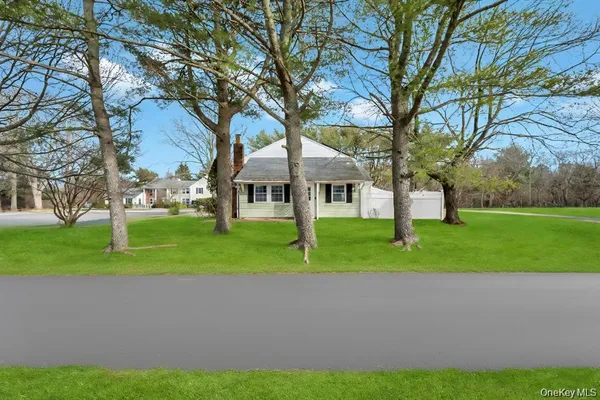 a front view of a house with garden and tree