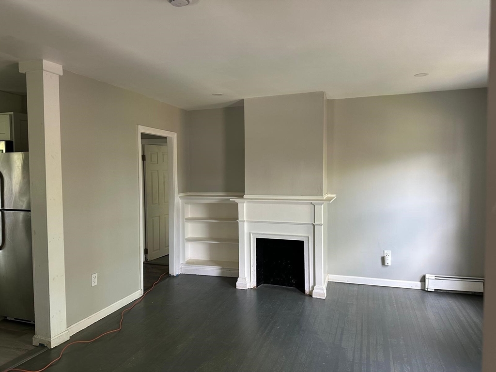 465 North Main Street, Unit 2 Randolph, MA 02368 - Photo 2 of 4 a view of an empty room with wooden floor and a window