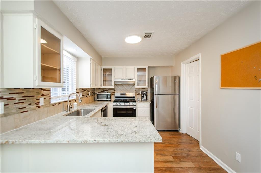 1066 Wedgewood Lane Tucker, GA 30084 - Photo 14 of 23 a kitchen with stainless steel appliances granite countertop a sink refrigerator and cabinets