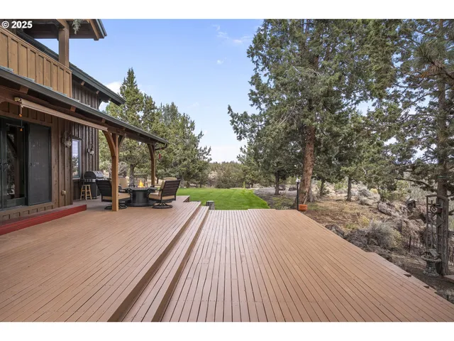 a view of a patio with table and chairs with wooden floor and fence