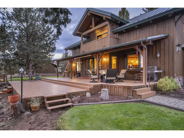a view of a patio with table and chairs potted plants and large tree