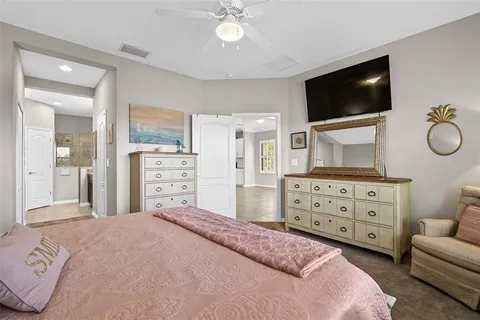 a bedroom with a bed a window and a flat screen tv