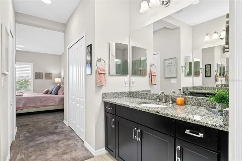 a en suite bathroom with a granite countertop sink mirror and double