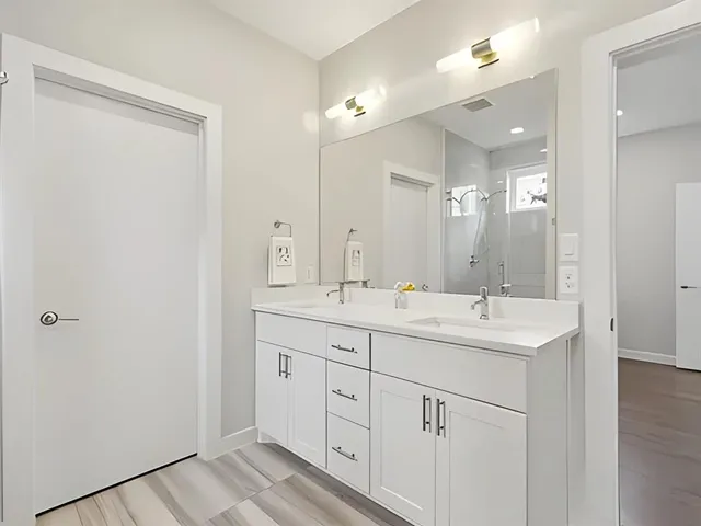 a bathroom with a double vanity sink and mirror
