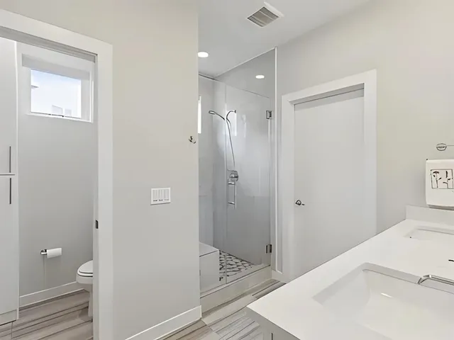 a bathroom with a sink a toilet and shower