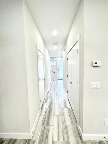 a view of a hallway with wooden floor and staircase