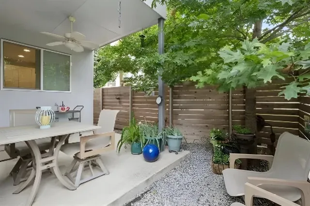 a view of a patio with table and chairs potted plants and large tree