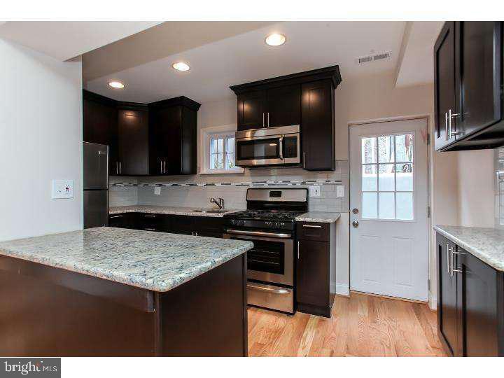 a kitchen with stainless steel appliances granite countertop a stove top oven a sink dishwasher and a microwave