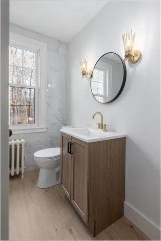 a bathroom with a toilet a sink and a mirror
