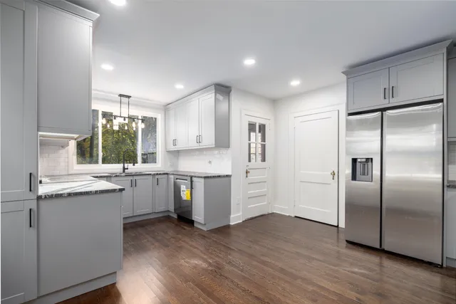 a kitchen with kitchen island white cabinets and stainless steel appliances