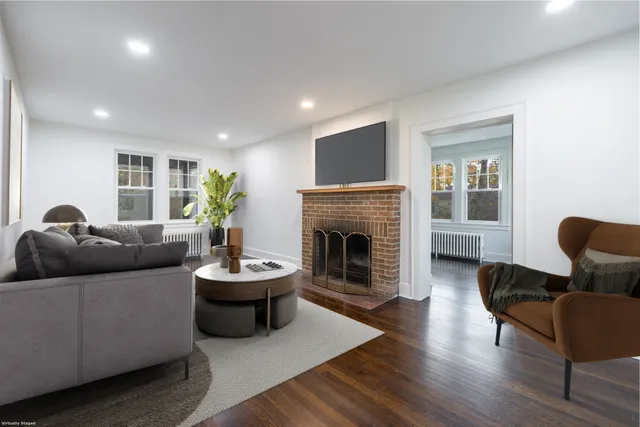 a living room with furniture a fireplace and a potted plant