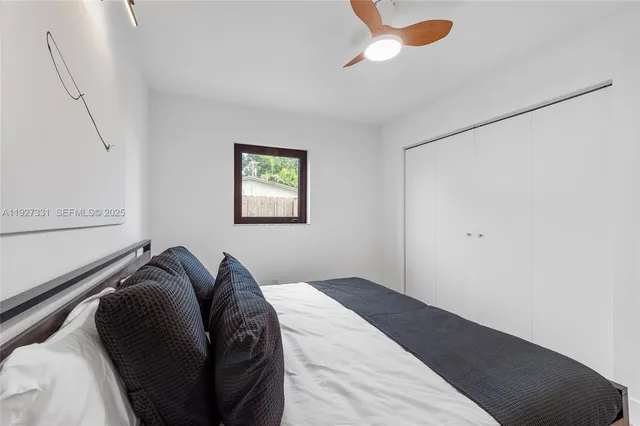 a bed sitting in a bedroom next to a window