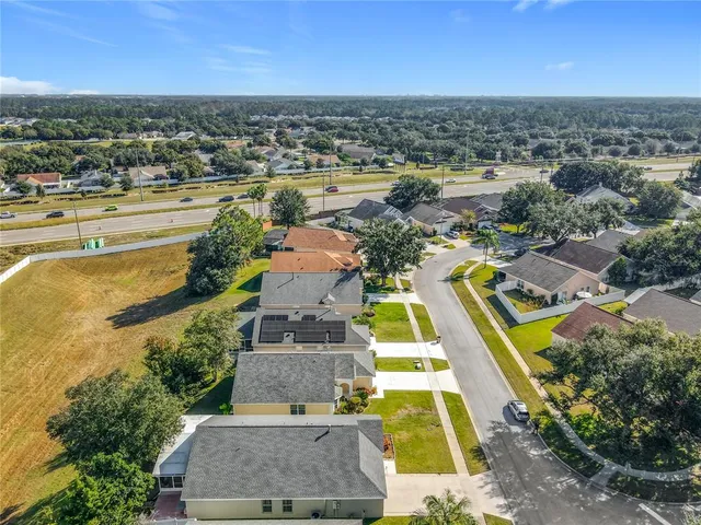 an aerial view of residential houses with outdoor space and ocean view