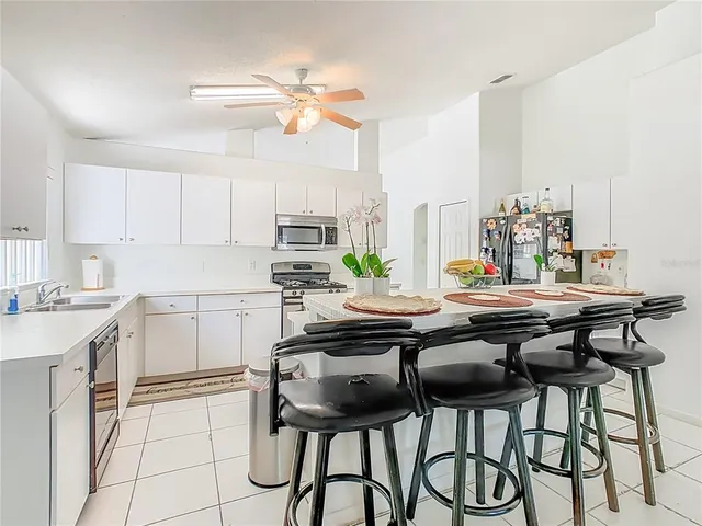 a kitchen with stainless steel appliances a table and chairs in it