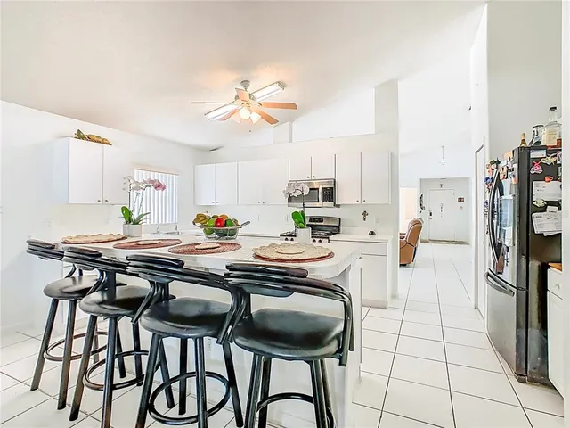 a kitchen with stainless steel appliances a table and chairs in it