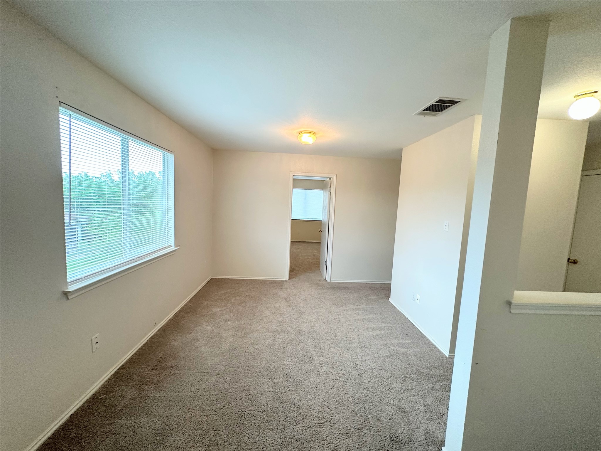 12929 Waynespur Lane Elgin, TX 78621 - Photo 11 of 20 This spacious area features carpeted flooring and a large window with blinds, providing natural light