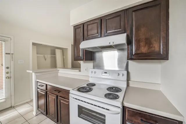 a kitchen with a stove cabinets and a refrigerator