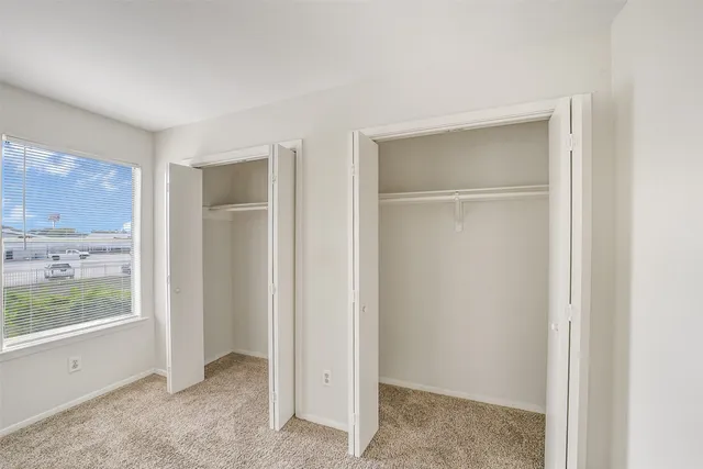 a view of an empty room with window and cabinet