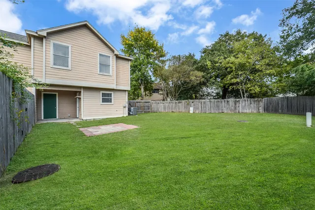 a view of a house with backyard and a tree