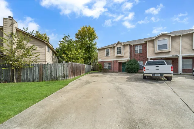 a car parked in front of a house with a yard