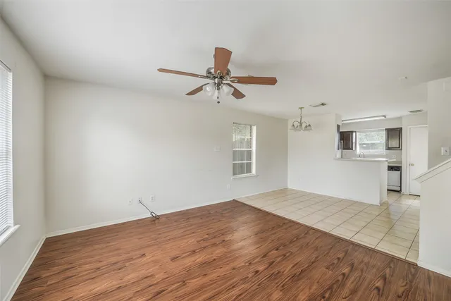 a view of empty room with wooden floor and ceiling fan