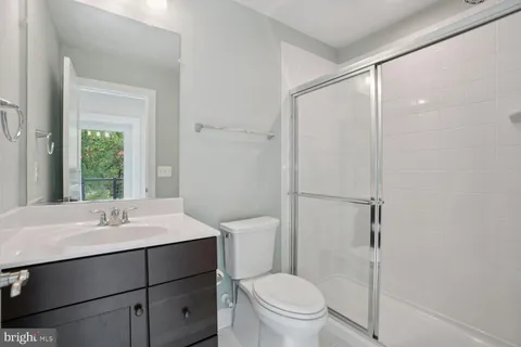 a bathroom with a sink toilet vanity and shower