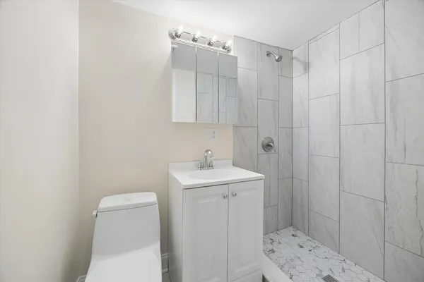 a bathroom with a sink a toilet and shower