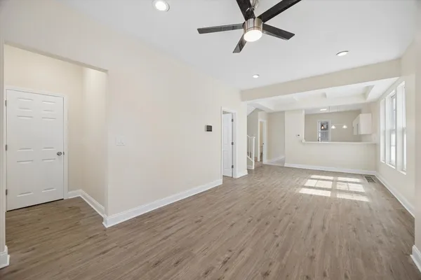 an empty room with wooden floor and windows