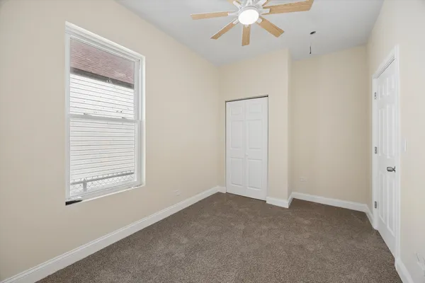 an empty room with a window and a fan