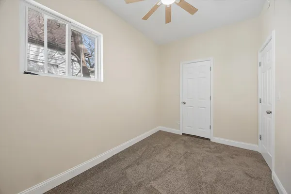 an empty room with a chandelier fan
