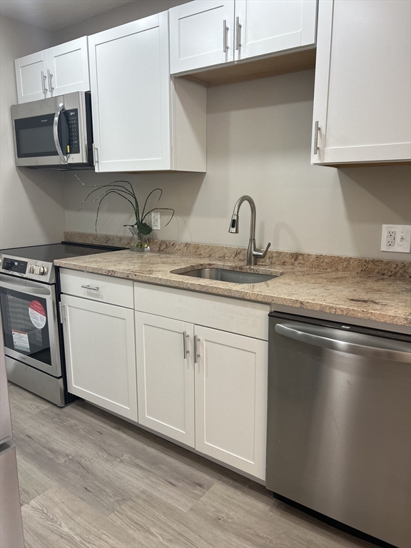 a kitchen with stainless steel appliances granite countertop a sink a stove and a microwave